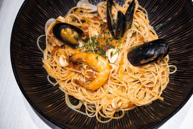 Büyük tabak makarna çeşitli deniz ürünleri ile yüksek açılı görünüş.