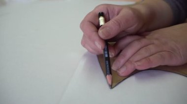 Yetenekli terzi daireleri kahverengi kağıt giysiler yakın plan.