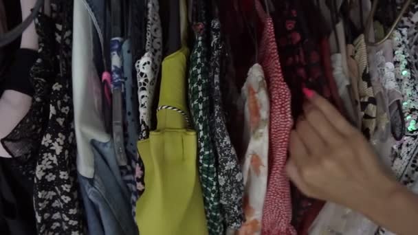 Kobieta klient wybiera stylowy strój wiszący na stojaku — Wideo stockowe