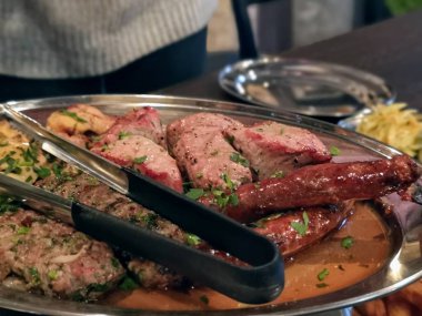 bir restoranda bir masada sosis ile et çanak