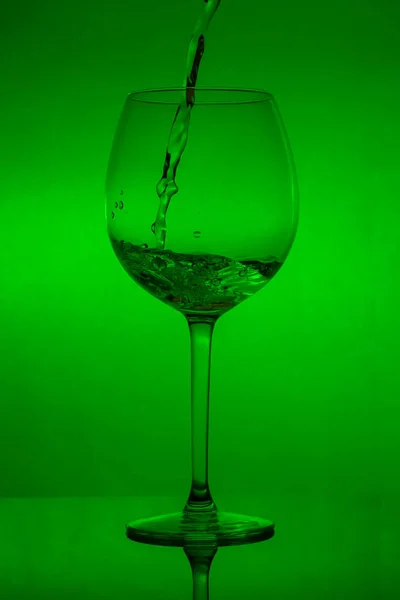 Enchendo Copo Derramando Vinho Fundo Verde — Fotografia de Stock