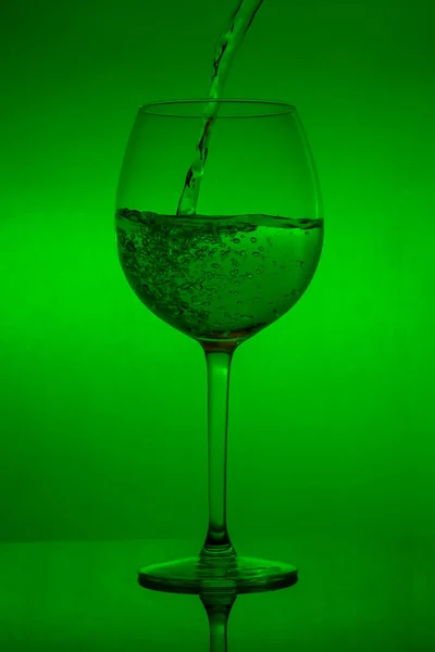 Enchendo Copo Derramando Vinho Fundo Verde — Fotografia de Stock