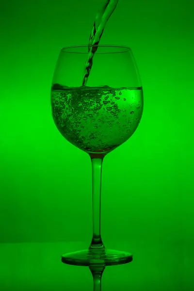Enchendo Copo Derramando Vinho Fundo Verde — Fotografia de Stock