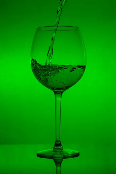 Enchendo Copo Derramando Vinho Fundo Verde — Fotografia de Stock