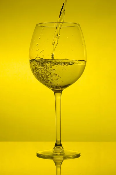 Γεμίζοντας Γυαλί Χύνοντας Χρώμα Του Κρασιού Κίτρινο Φόντο — Φωτογραφία Αρχείου