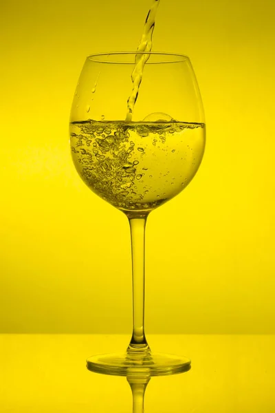 Enchendo Copo Derramando Vinho Sobre Fundo Amarelo — Fotografia de Stock