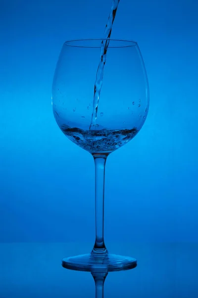 Γεμίζοντας Γυαλί Χύνοντας Χρώμα Του Κρασιού Μπλε Φόντο — Φωτογραφία Αρχείου
