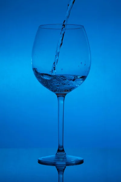 Enchendo Copo Derramando Vinho Fundo Azul — Fotografia de Stock