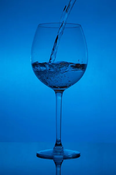 Enchendo Copo Derramando Vinho Fundo Azul — Fotografia de Stock