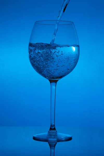 Enchendo Copo Derramando Vinho Fundo Azul — Fotografia de Stock