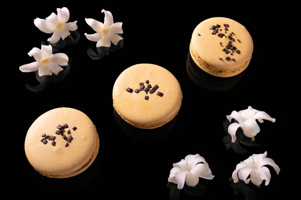 Zoete Macarons Bitterkoekjes Versierd Met Bloeiende Bloemen Een Zwarte Achtergrond — Stockfoto