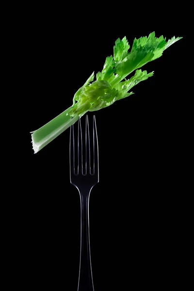 带黑色背景的叉子上的芹菜 — 图库照片