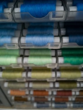 Dikiş için plastik bobinler üzerinde farklı renklerde birçok dikiş iplikleri, iğne için.