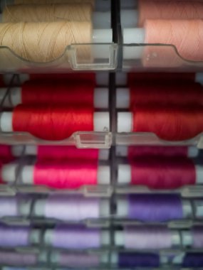 Dikiş için plastik bobinler üzerinde farklı renklerde birçok dikiş iplikleri, iğne için.