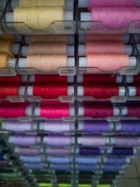 Dikiş için plastik bobinler üzerinde farklı renklerde birçok dikiş iplikleri, iğne için.