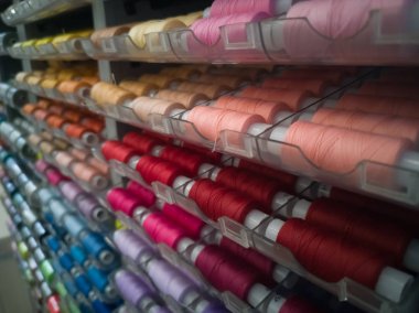 Dikiş için plastik bobinler üzerinde farklı renklerde birçok dikiş iplikleri, iğne için.