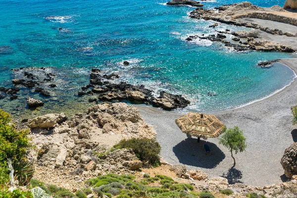 Lounge chairs and umbrella on the pebbles beach. — Stock Photo, Image