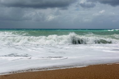 Rodos'ta Ege Denizi'nin kum sahilinde dalgalar.