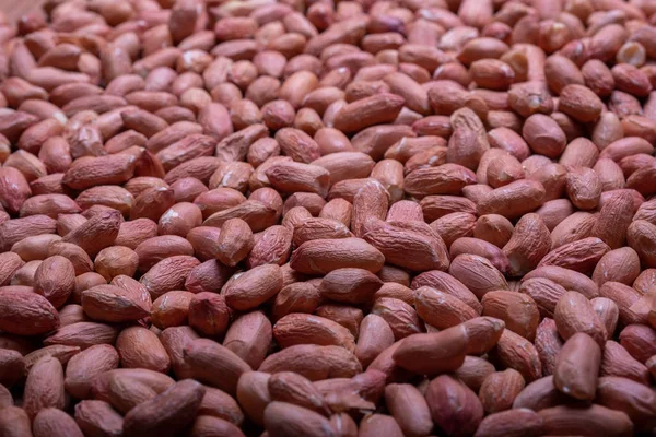 Amendoins espalhados em uma mesa de madeira. Feijão de amendoim close-up . — Fotografia de Stock