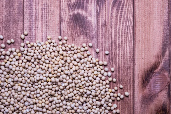 Soybeans scattered on a wooden table. Soy beans — Stock Photo, Image