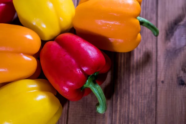 Bunter frischer Paprika auf einem dunklen Holztisch Stockbild