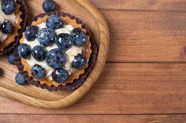 masada ahşap bir tabak üzerinde böğürtlen tartlet, böğürtlen pişmiş 