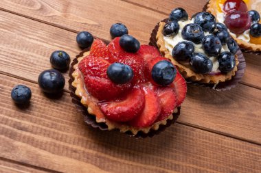 masada ahşap bir tabak üzerinde meyve tartlets, meyve pişmiş kabuk