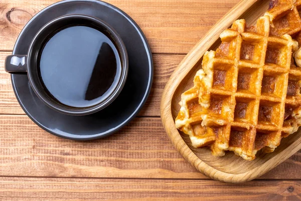 Waffle on a plate and cup of coffee on the wooden table — Stock Photo, Image