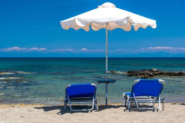 Şezlonglar ve plajda şemsiye, deniz kıyısında.