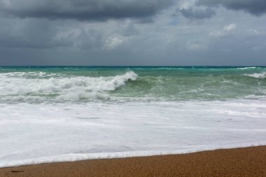 Rodos'ta Ege Denizi'nin kum sahilinde dalgalar.