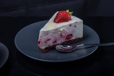 bir bla çilek ile süslenmiş krem meyve li kek bir parça