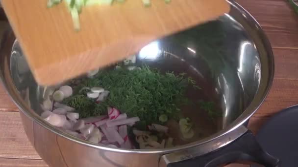 Повар наливает нарезанные овощи в кастрюлю, крупным планом нарезанные овощи — стоковое видео