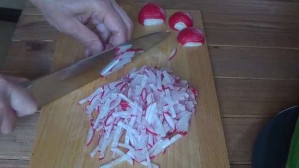 Cocinar rodajas de rábano en una tabla de cortar, cerrar cortar los rábanos — Vídeo de stock