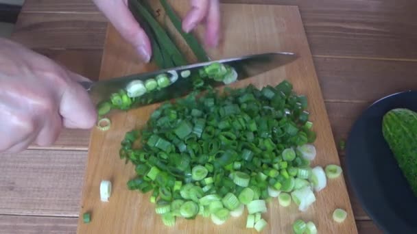 Bir kesme tahtası üzerinde yeşil soğan pişirmek, yakın doğrayın yeşil soğan — Stok video