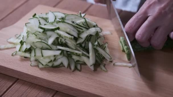 Cook skivor gurkor på en skärbräda, närbild skivning gurkor — Stockvideo