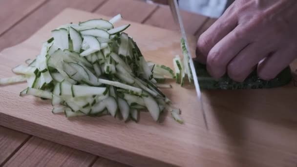 Cook skivor gurkor på en skärbräda, närbild skivning gurkor — Stockvideo