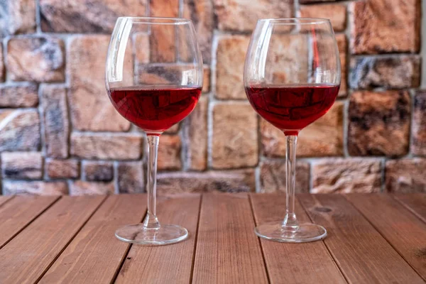 Δύο ποτήρια κόκκινο κρασί σε ξύλινο τραπέζι — Φωτογραφία Αρχείου