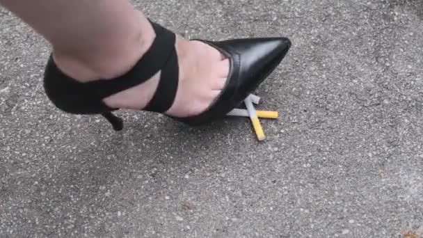 女孩踩香烟在沥青上 停止吸烟 — 图库视频影像