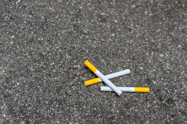 Trois cigarettes couchées sur le trottoir — Photo