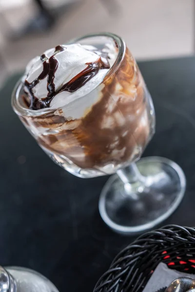 Sirop de chocolat recouvert de crème glacée sur un verre sur la table — Photo