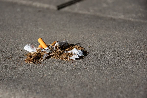 Trois cigarettes écrasées couchées sur le trottoir — Photo