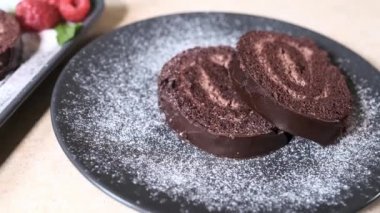 şef ortaya koyar ve doğranmış çikolata İsviçre rulo süsler. Swiss Roll ahududu ile dekore edilmiştir. Pasta.