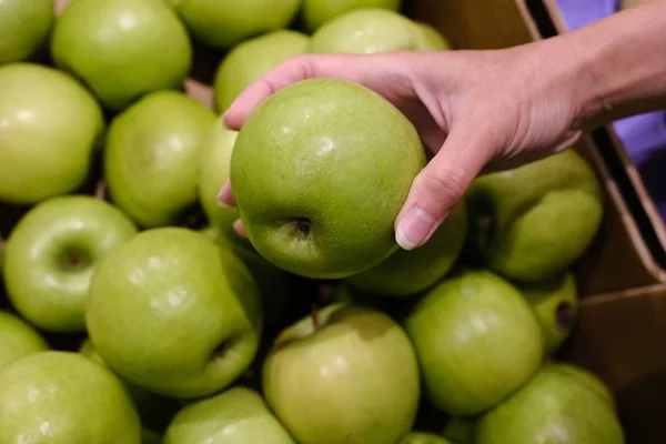 Frau wählt Äpfel im Laden. Theke in Äpfeln im Supermarkt — Stockfoto