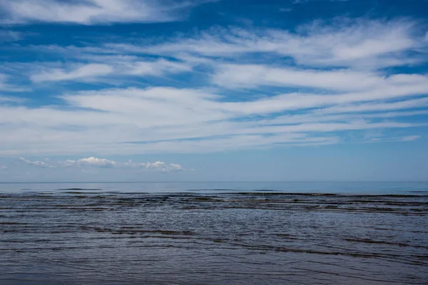 Donkere zee en blauwe hemel met witte wolken. — Stockfoto