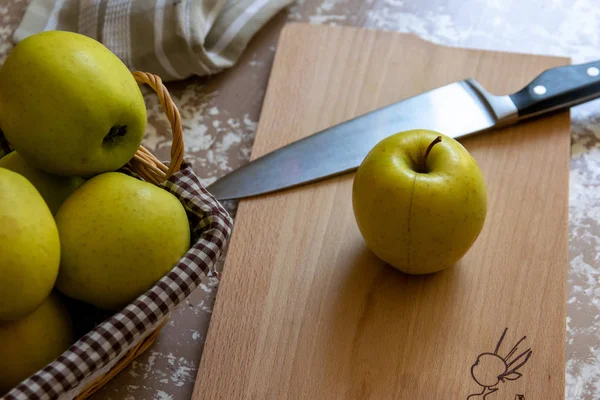 Messer und Apfel auf einem Schneidebrett auf einem Tisch in der Küche. ch — Stockfoto