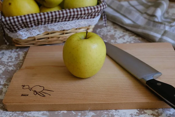 Coltello e mela su un tagliere su un tavolo in cucina. Ch — Foto Stock