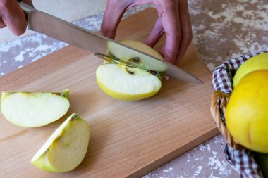 Bir t üzerinde bir kesme tahtasında dilimleri için bıçak bir elma tarafından kadın keser