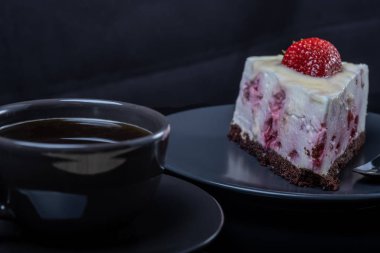 krem meyve pastası ve bir bardak siyah kahve siyah cam TABL