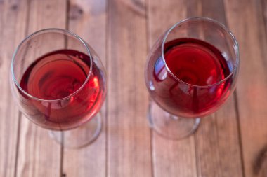 Tahta bir masada iki kadeh kırmızı şarap.