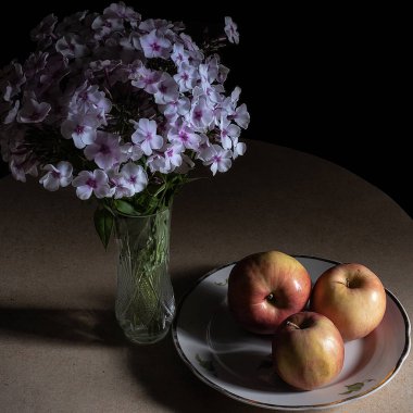 Mutfaktaki masada tabakta üç elma ve phlox var. Düşük